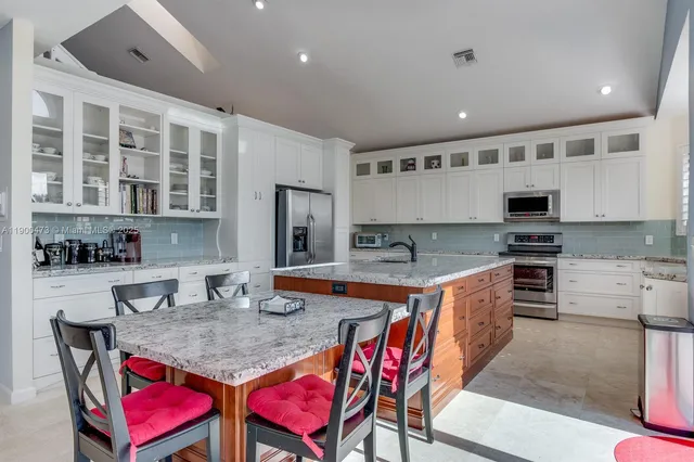 a kitchen with stainless steel appliances granite countertop a stove and white cabinets
