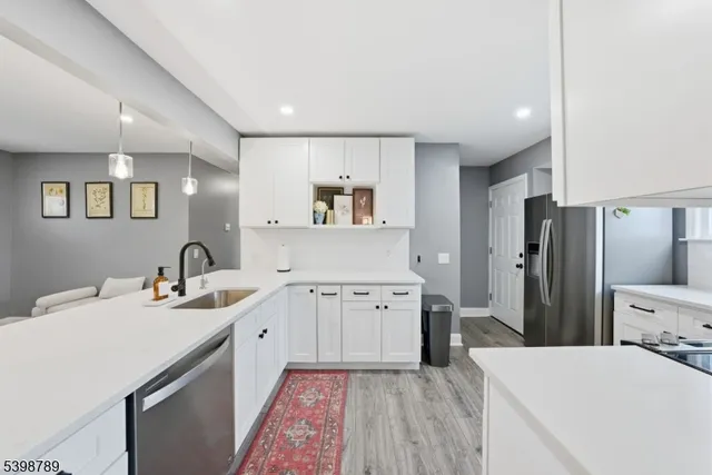 a kitchen with a sink a refrigerator and cabinets