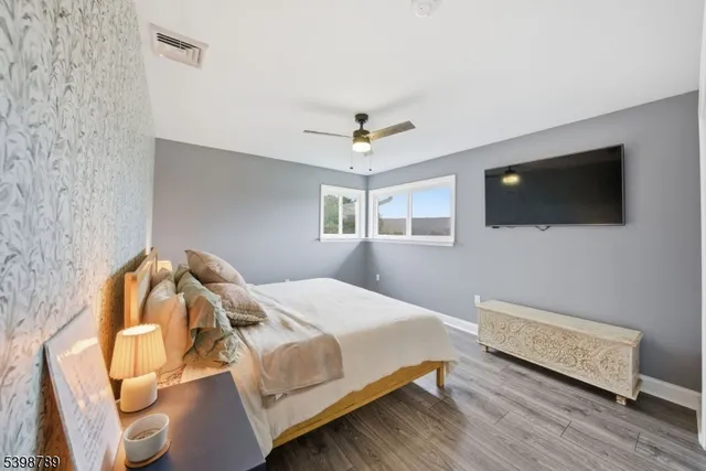 a bedroom with a bed a flat screen tv and a chandelier