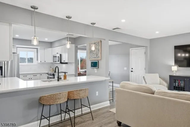 a large living room with stainless steel appliances kitchen island granite countertop furniture and a fireplace