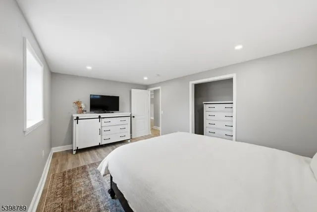 a large bedroom with a bed and a flat screen tv