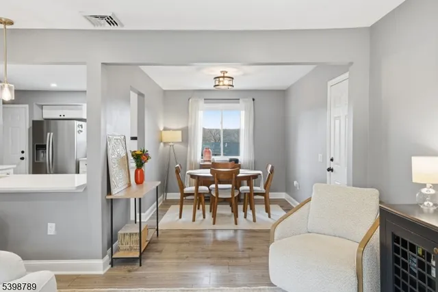 a living room with furniture a dining table and a large window