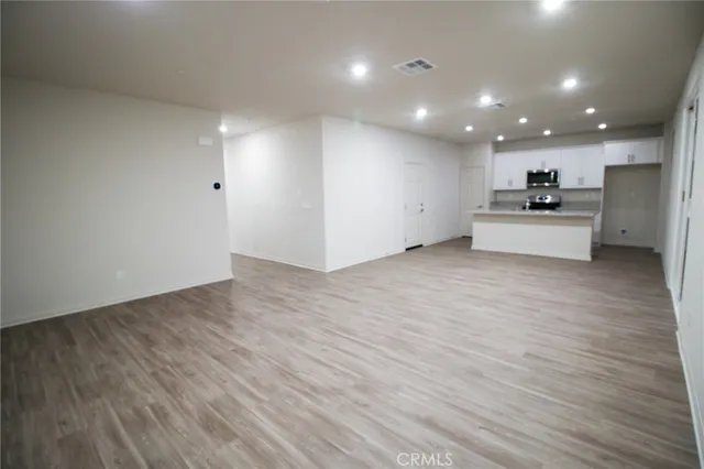 a view of kitchen with kitchen island wooden floor center island and stainless steel appliances with wooden floor