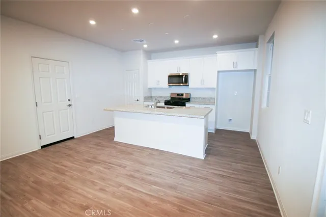 a kitchen with stainless steel appliances a sink a stove a refrigerator and cabinets