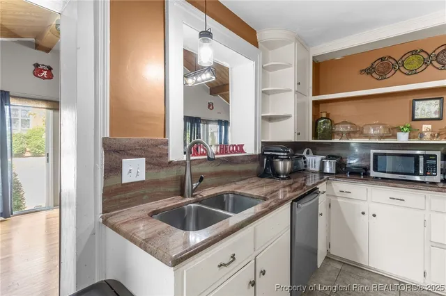 a kitchen with granite countertop a sink and cabinets