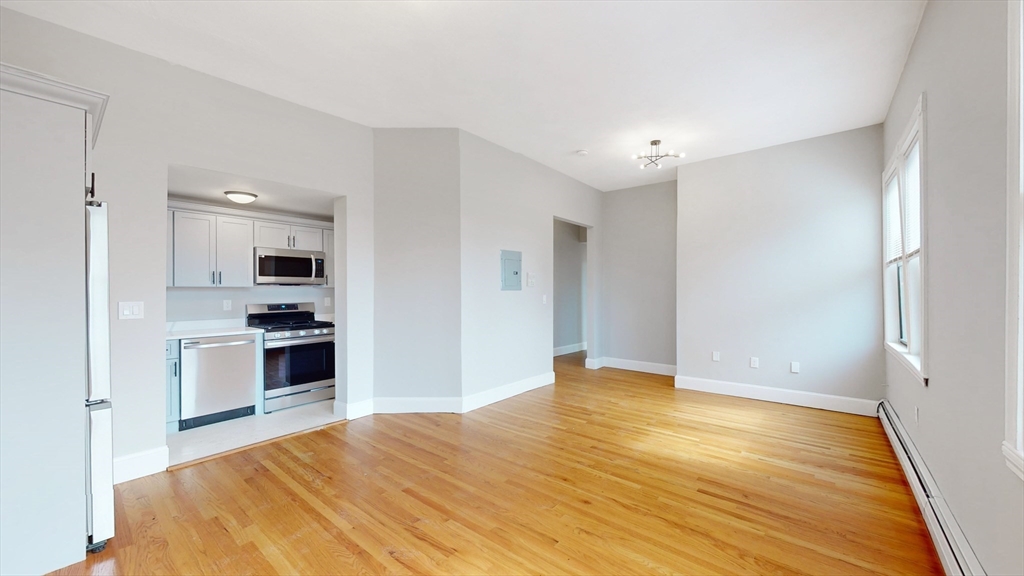181 Highland Street, Unit 1 Boston, MA 02119 - Photo 2 of 11 a bedroom with a bed and a view of kitchen
