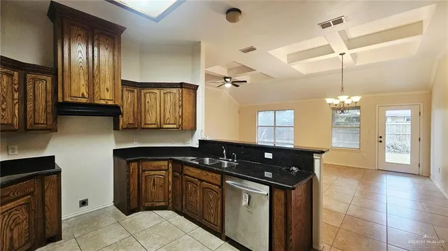 a kitchen with granite countertop a sink a stove and cabinets