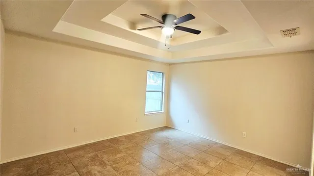 an empty room with a window and a ceiling fan