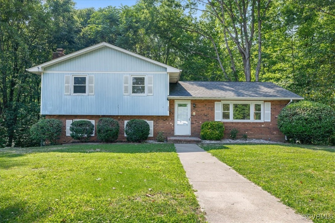 Tri-level home featuring brick siding and a front
