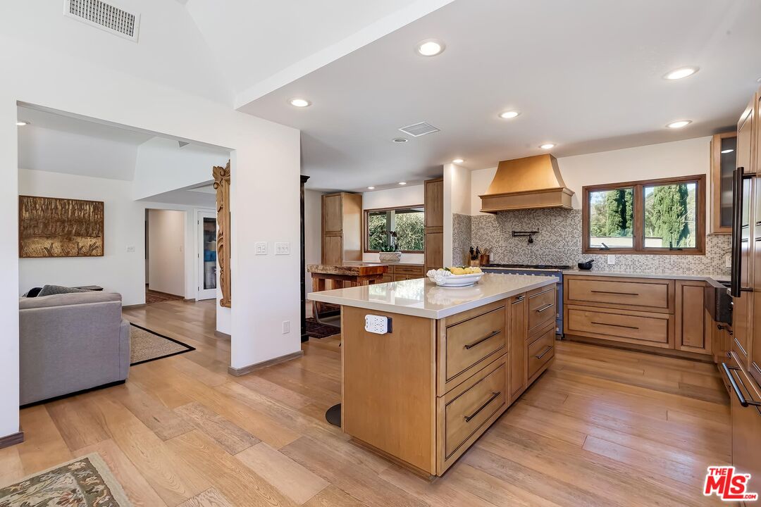 24537 Dry Canyon Cold Creek Road Calabasas, CA 91302 - Photo 14 of 54 a kitchen with stainless steel appliances granite countertop a lot of cabinets and wooden floor