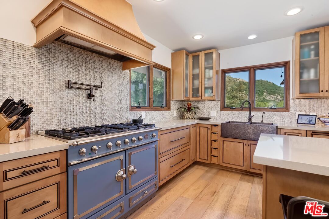 24537 Dry Canyon Cold Creek Road Calabasas, CA 91302 - Photo 16 of 54 a kitchen with stainless steel appliances granite countertop wooden cabinets stove top oven and sink
