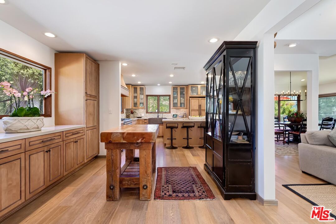 24537 Dry Canyon Cold Creek Road Calabasas, CA 91302 - Photo 17 of 54 a kitchen with stainless steel appliances granite countertop a refrigerator a sink dishwasher a dining table and chairs with wooden floor