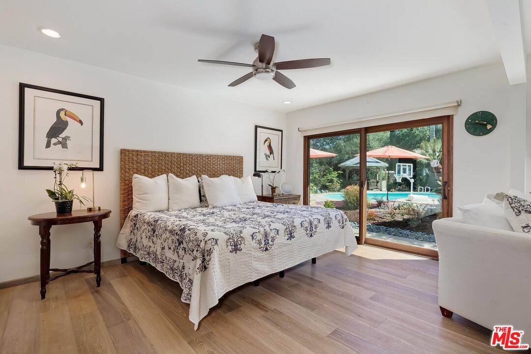 24537 Dry Canyon Cold Creek Road Calabasas, CA 91302 - Photo 19 of 54 a bedroom with a large bed and a chandelier