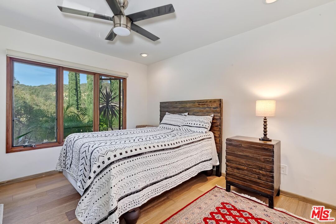 24537 Dry Canyon Cold Creek Road Calabasas, CA 91302 - Photo 22 of 54 a bedroom with a bed and a dresser next to a window