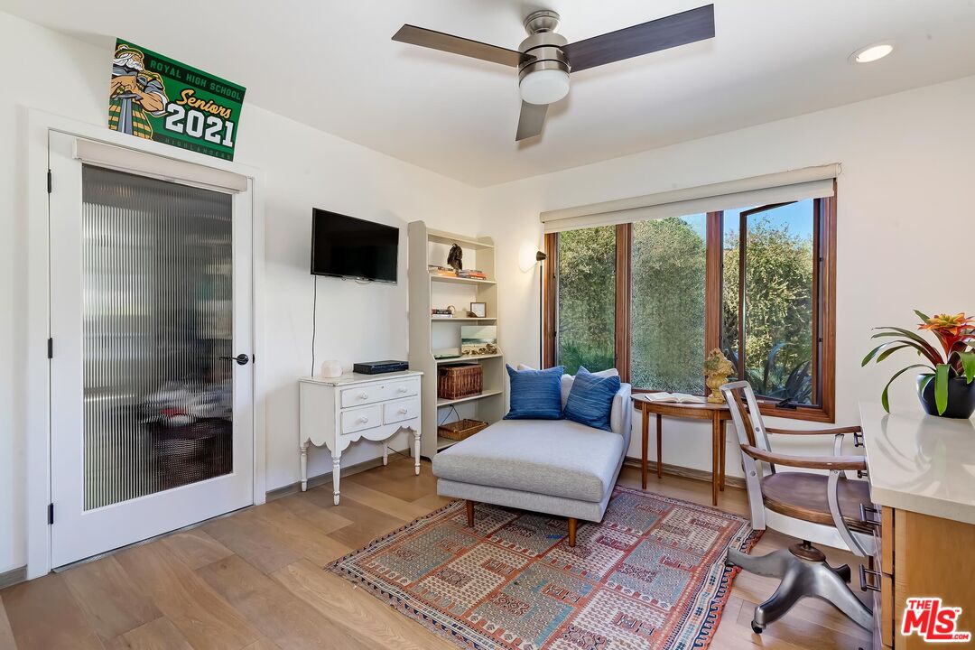24537 Dry Canyon Cold Creek Road Calabasas, CA 91302 - Photo 23 of 54 a living room with furniture a flat screen tv and a floor to ceiling window