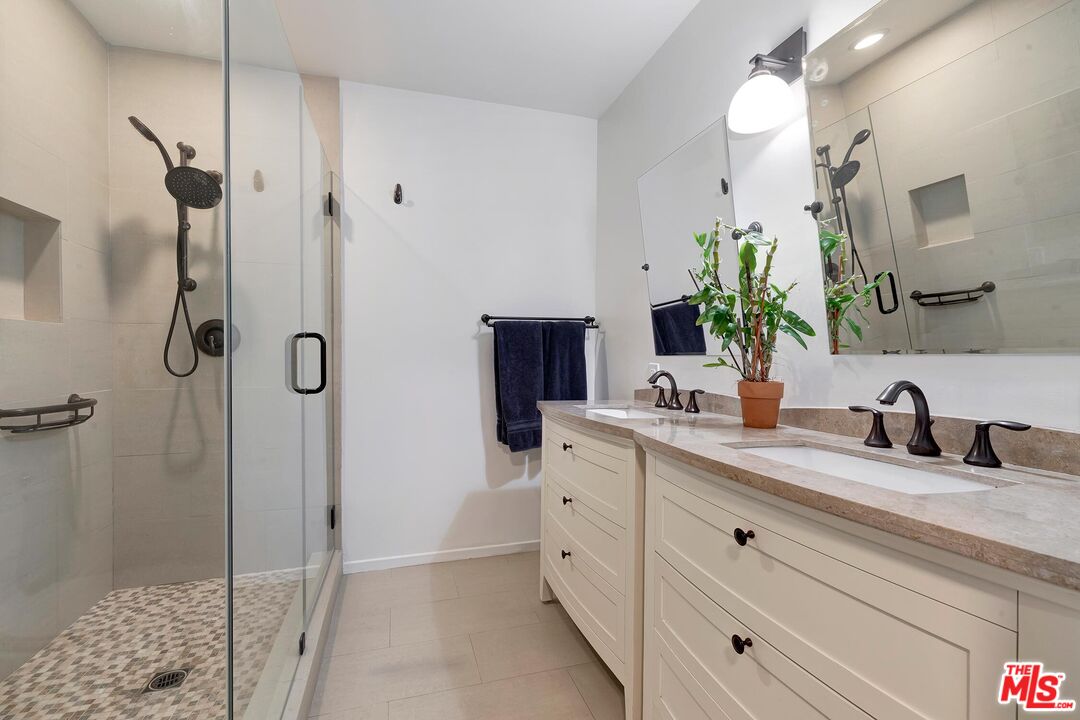 24537 Dry Canyon Cold Creek Road Calabasas, CA 91302 - Photo 24 of 54 a bathroom with a double vanity sink a mirror and shower