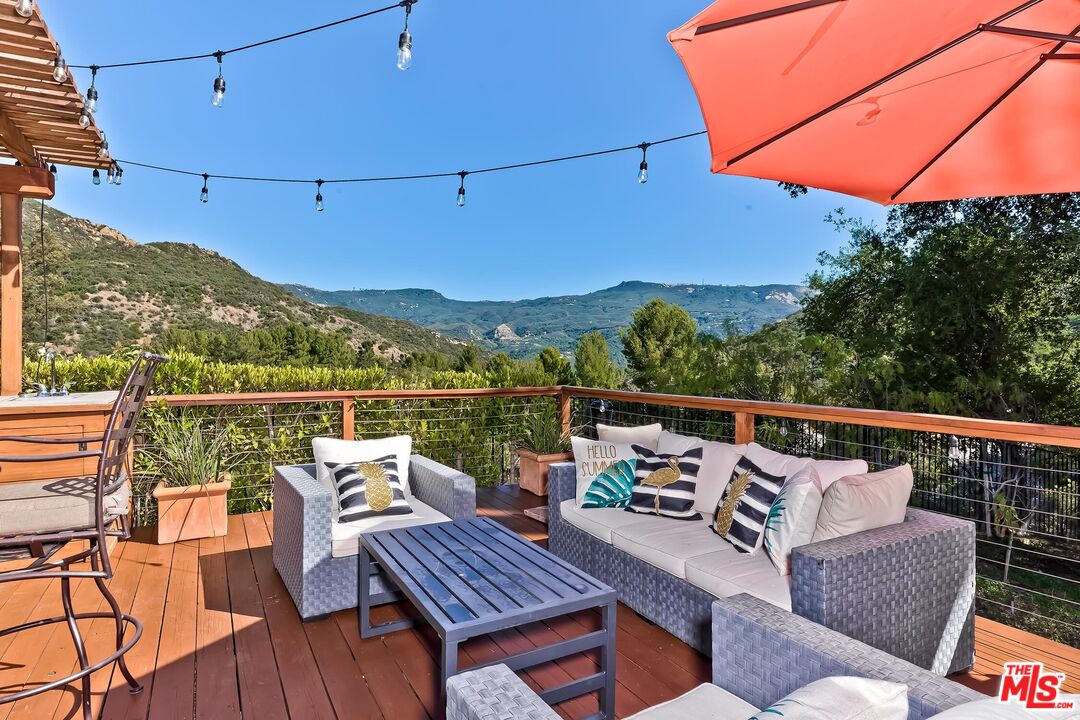 24537 Dry Canyon Cold Creek Road Calabasas, CA 91302 - Photo 25 of 54 a view of a roof deck with couches and wooden floor