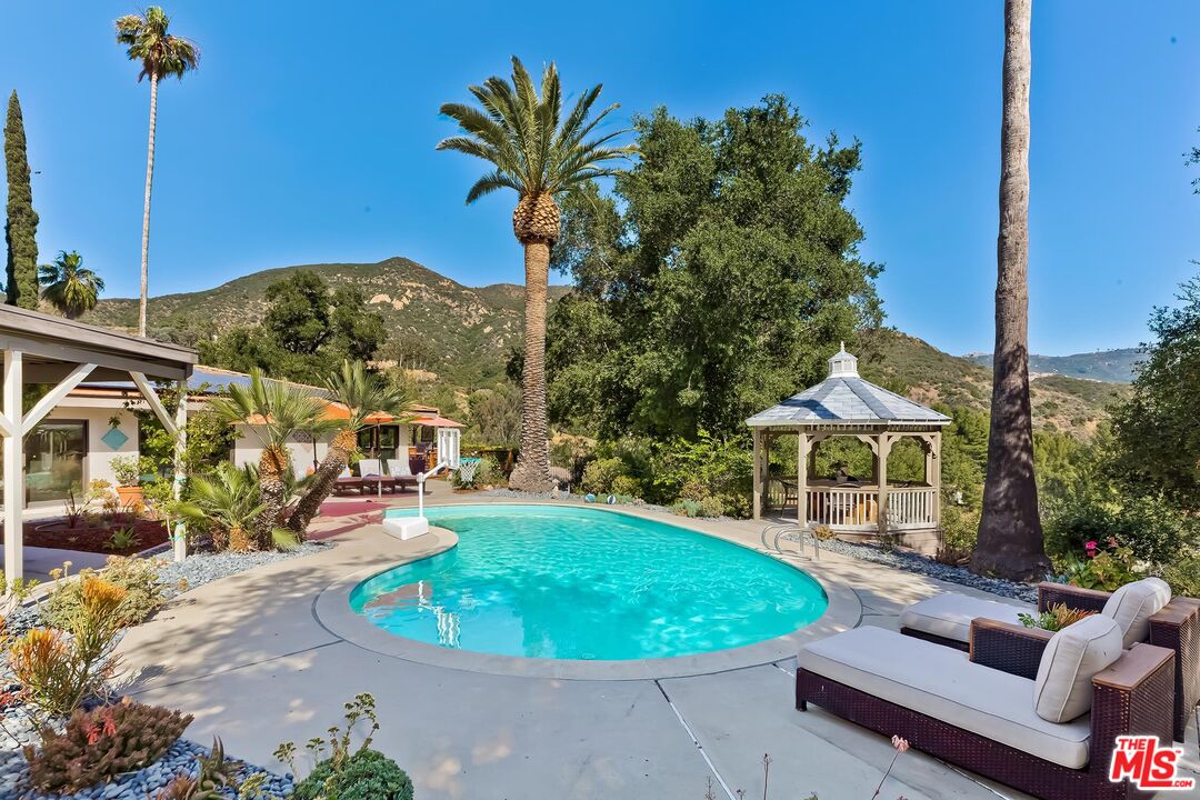 24537 Dry Canyon Cold Creek Road Calabasas, CA 91302 - Photo 27 of 54 a view of a swimming pool with a patio and a yard