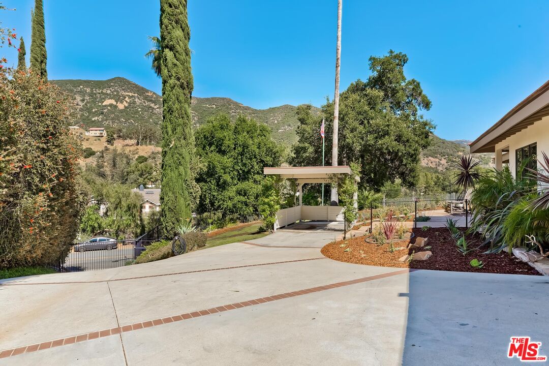 24537 Dry Canyon Cold Creek Road Calabasas, CA 91302 - Photo 3 of 54 a view of a patio with couches table and chairs and potted plants