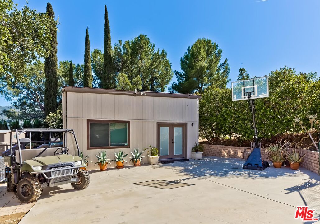 24537 Dry Canyon Cold Creek Road Calabasas, CA 91302 - Photo 35 of 54 a view of a patio with a table and chairs under an umbrella