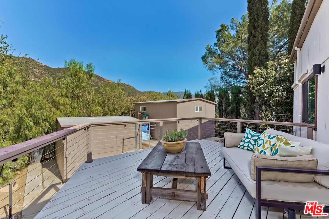 24537 Dry Canyon Cold Creek Road Calabasas, CA 91302 - Photo 38 of 54 a balcony with wooden floor and outdoor seating