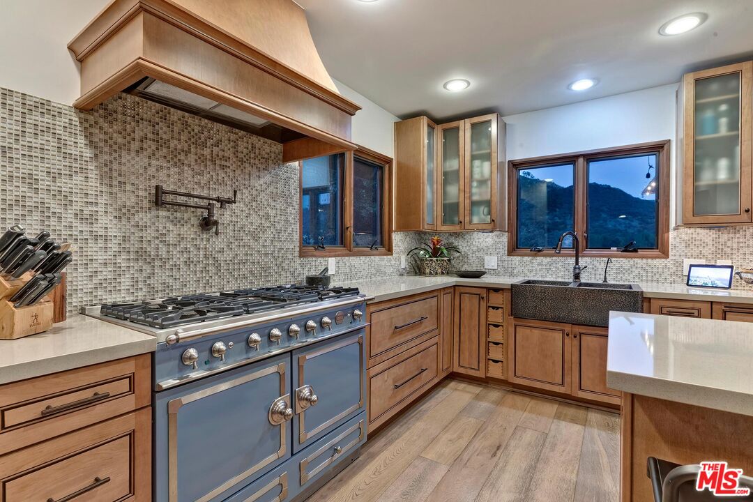 24537 Dry Canyon Cold Creek Road Calabasas, CA 91302 - Photo 45 of 54 a kitchen with stainless steel appliances granite countertop wooden cabinets stove top oven and sink