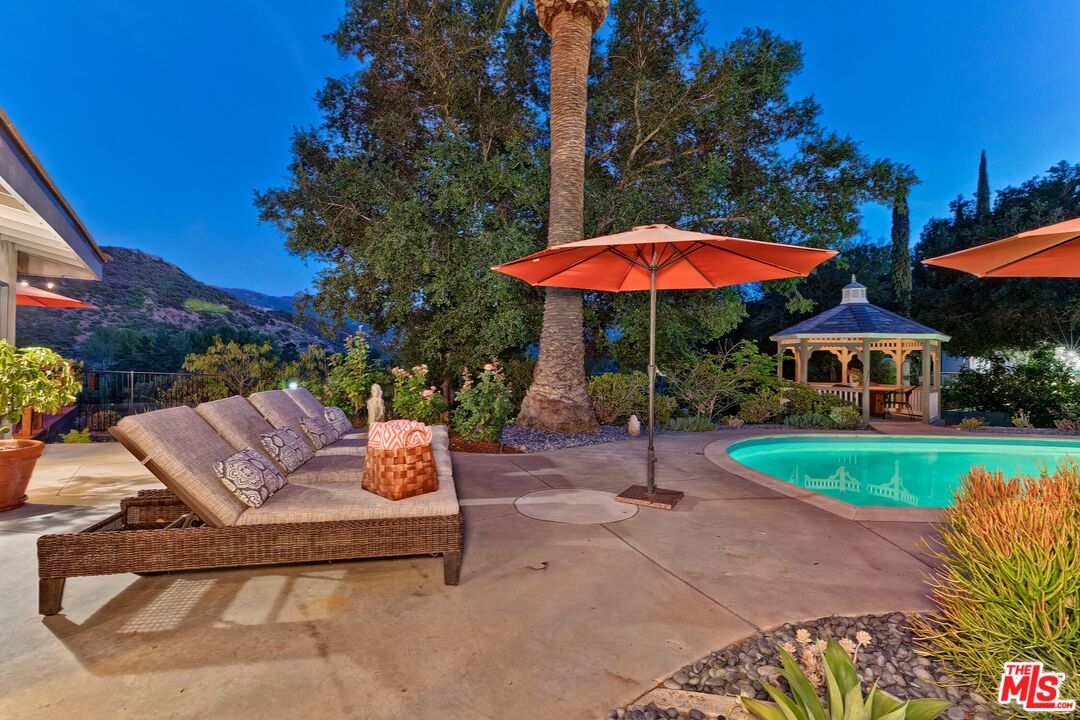 24537 Dry Canyon Cold Creek Road Calabasas, CA 91302 - Photo 49 of 54 a view of a table and chairs under an umbrella in patio