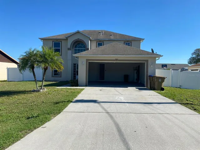 a front view of a house with a garden and garage