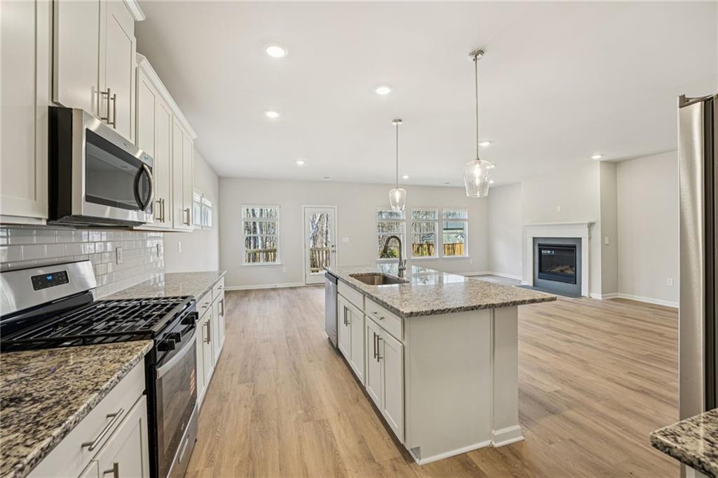 4412 Brick Tunl Street Powder Springs, GA 30127 - Photo 27 of 72 a kitchen with a sink stove top oven and cabinets