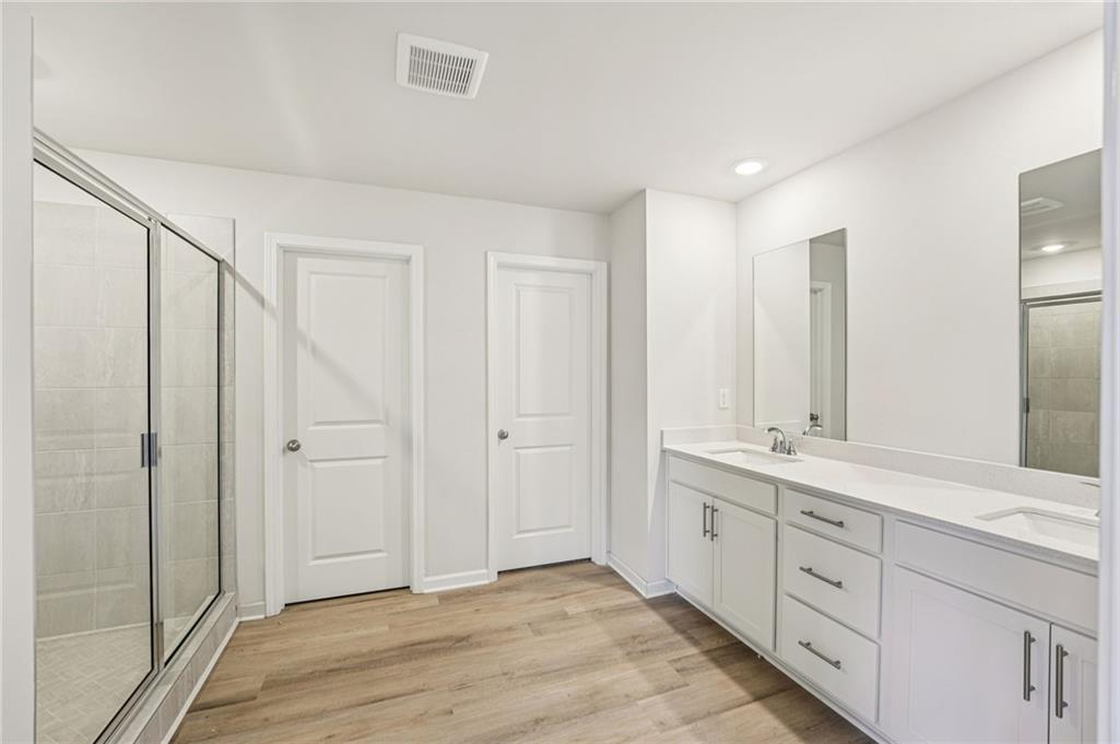 4412 Brick Tunl Street Powder Springs, GA 30127 - Photo 51 of 72 a spacious bathroom with a double vanity sink and a mirror