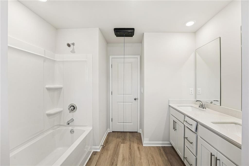 4412 Brick Tunl Street Powder Springs, GA 30127 - Photo 56 of 72 a bathroom with a tub sink double vanity and a mirror