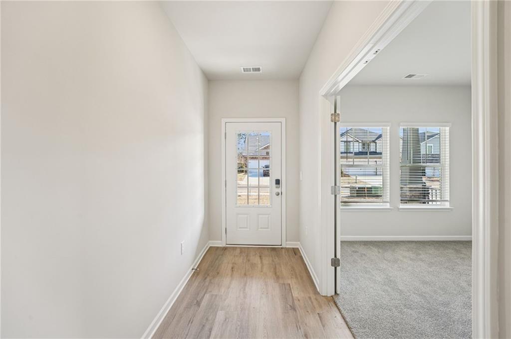 4412 Brick Tunl Street Powder Springs, GA 30127 - Photo 8 of 72 a view of an empty room with wooden floor and a window