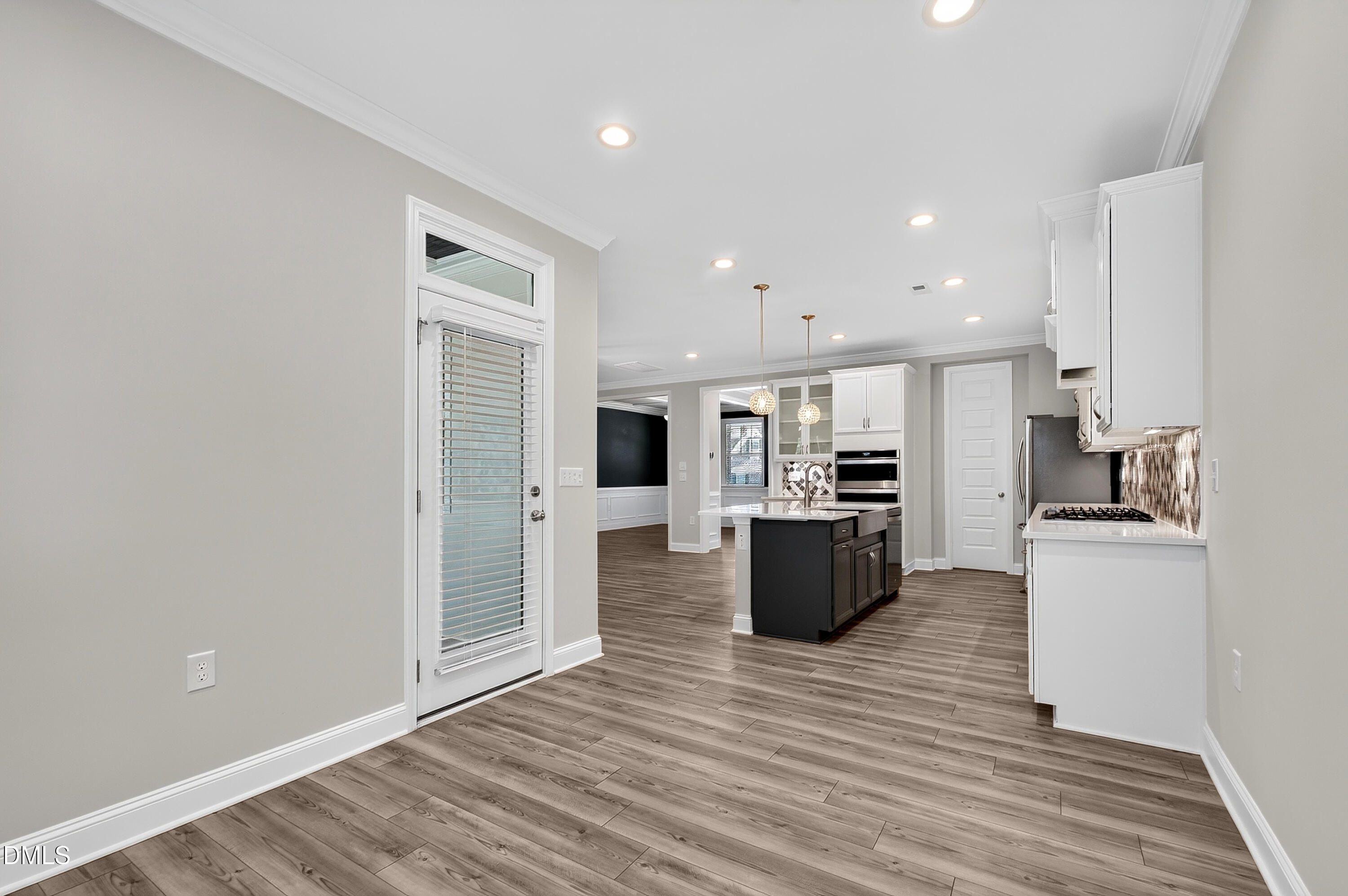 1300 Commons Ford Place Apex, NC 27539 - Photo 23 of 70 a large kitchen with stainless steel appliances granite countertop a stove top oven a sink dishwasher and a refrigerator with wooden floor