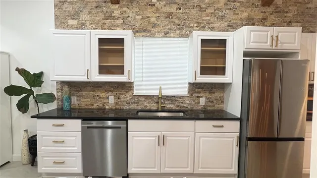 a kitchen with stainless steel appliances granite countertop a refrigerator and a stove