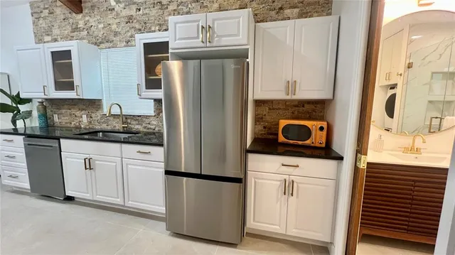 a kitchen with appliances a refrigerator and cabinets