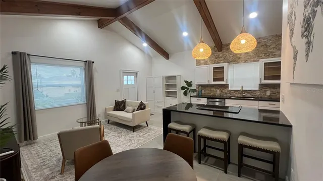 a kitchen with stainless steel appliances granite countertop a stove a sink dishwasher and white cabinets with wooden floor