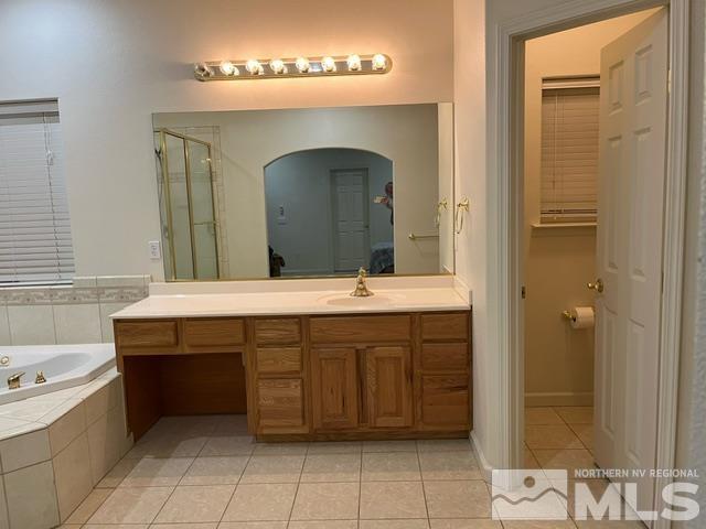 4335 Rancheria Road Fallon, NV 89406 - Photo 19 of 36 a bathroom with a double vanity sink a mirror and a bathtub