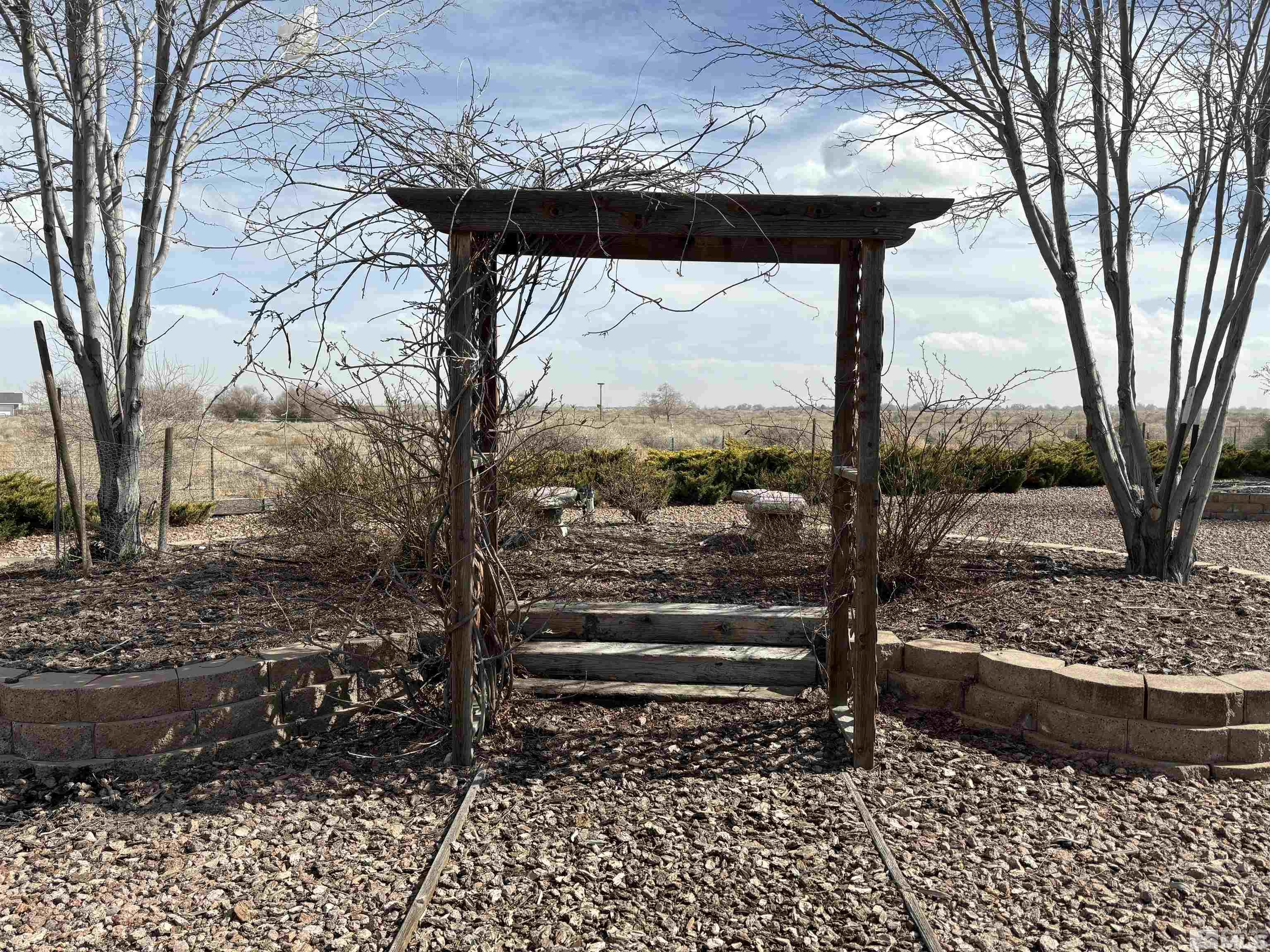 4335 Rancheria Road Fallon, NV 89406 - Photo 28 of 36 a view of a yard with a bench and trees