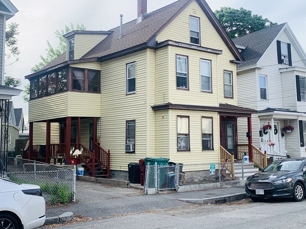 a front view of a house with cars parked
