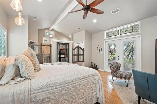 a bedroom with a large bed and a chandelier