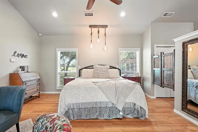 a bedroom with a large bed and wooden floor
