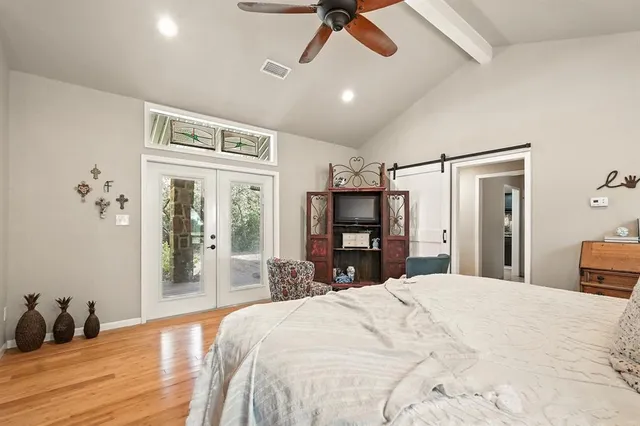 a bedroom with a large bed and a large mirror