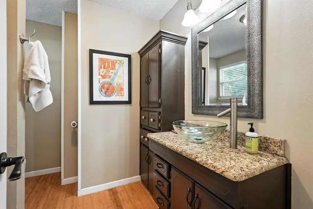 a bathroom with a granite countertop sink and a mirror