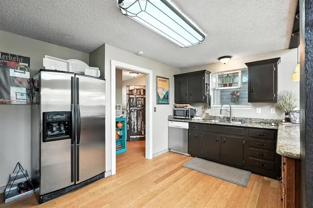 a large kitchen with stainless steel appliances granite countertop a refrigerator and a sink