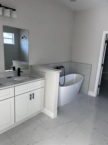 a spacious bathroom with a granite countertop sink and mirror
