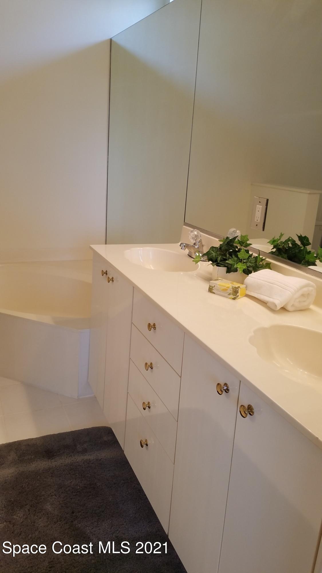 2492 Addington Circle Rockledge, FL 32955 - Photo 17 of 34 a bathroom with a sink and a mirror