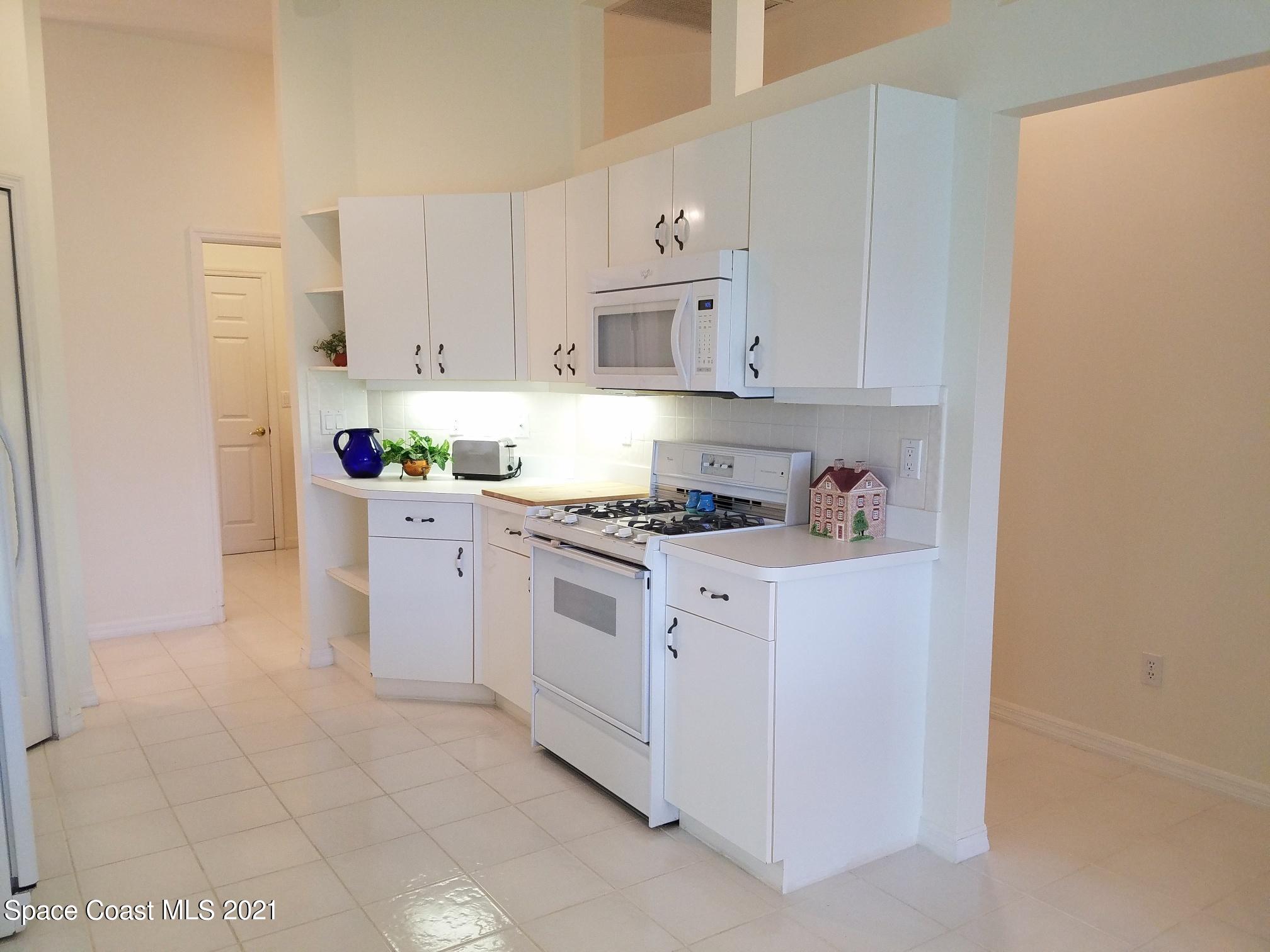 2492 Addington Circle Rockledge, FL 32955 - Photo 8 of 34 a kitchen with granite countertop a sink a stove and cabinets