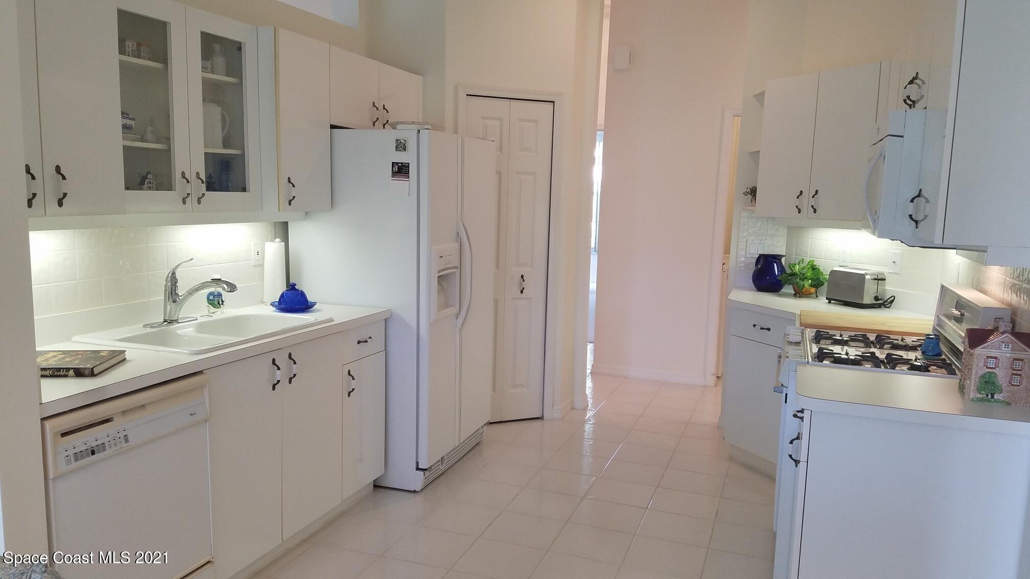 2492 Addington Circle Rockledge, FL 32955 - Photo 9 of 34 a kitchen with white cabinets and sink