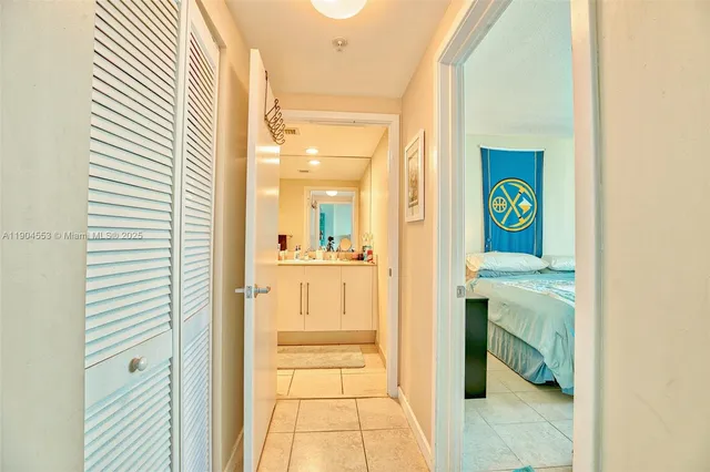 a hallway with cabinets a sink a window and a refrigerator