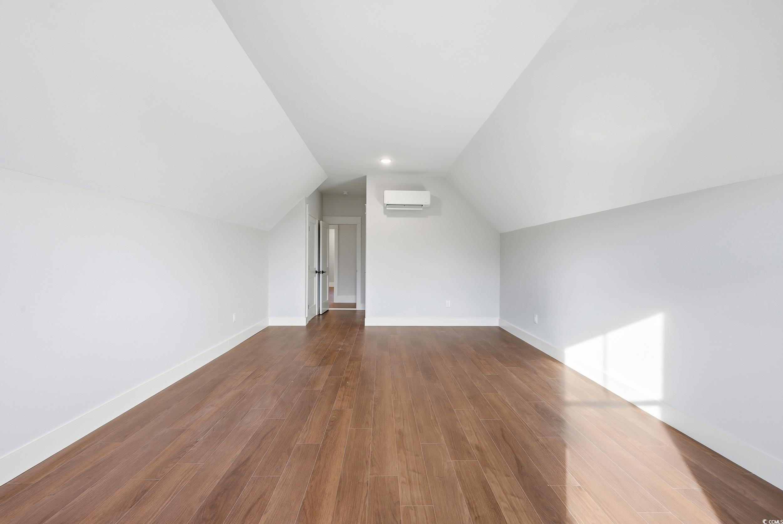 813 Commanders Island Road Georgetown, SC 29440 - Photo 32 of 39 Bonus room with lofted ceiling, dark wood finished floors, and a wall mounted air conditioner